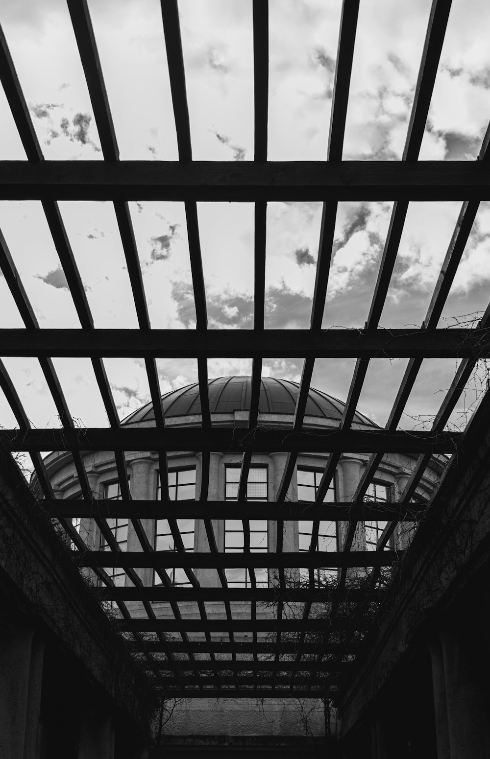 a black and white photo of a building under a cloudy sky