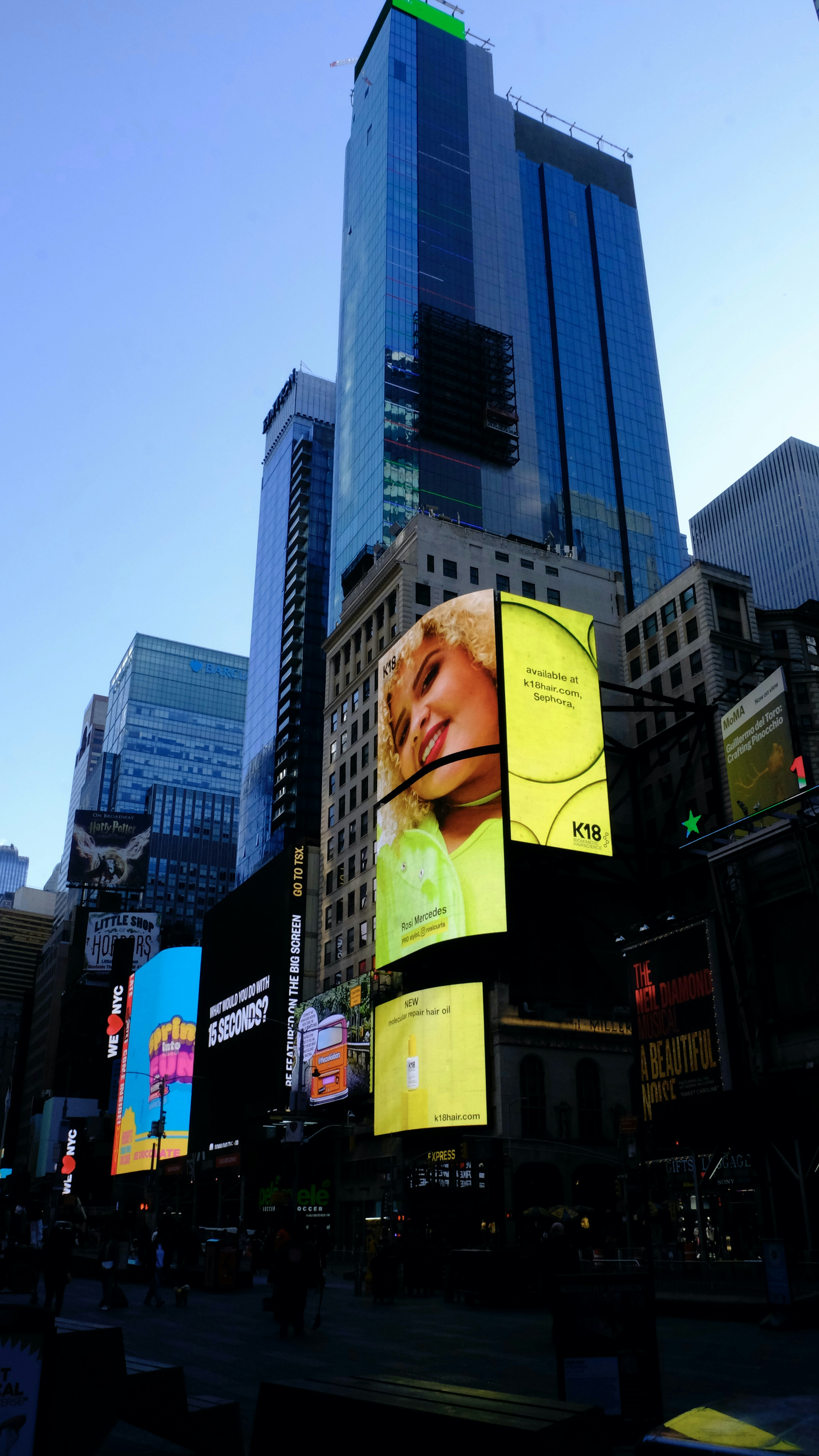 Bright digital billboard advertisement display in urban street at dusk dark atmospheric environment with city lights