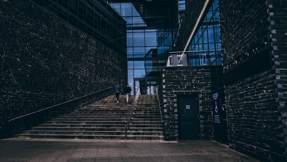 a man walking down a flight of stairs next to a building