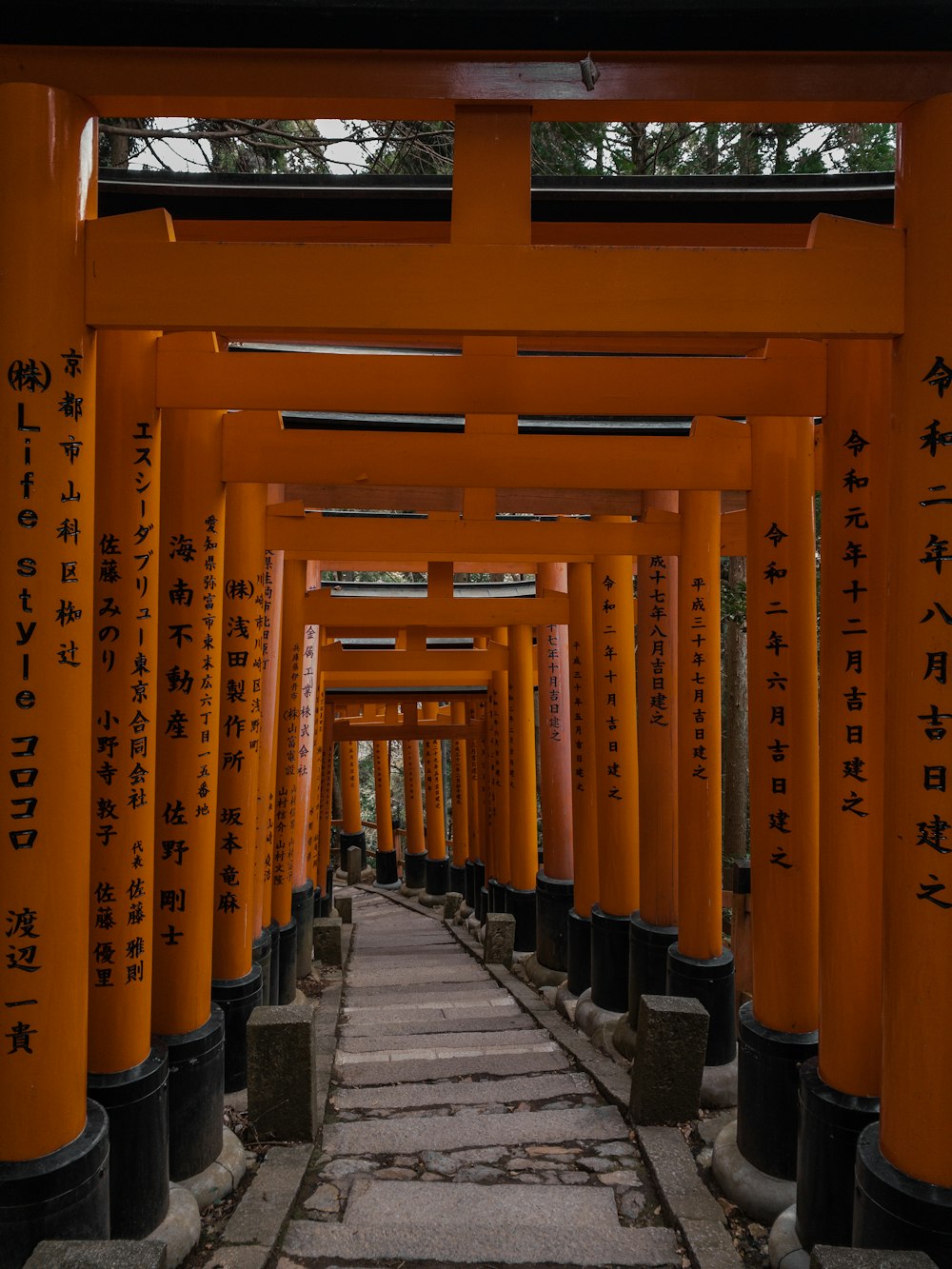a walkway lined with lots of tall orange pillars