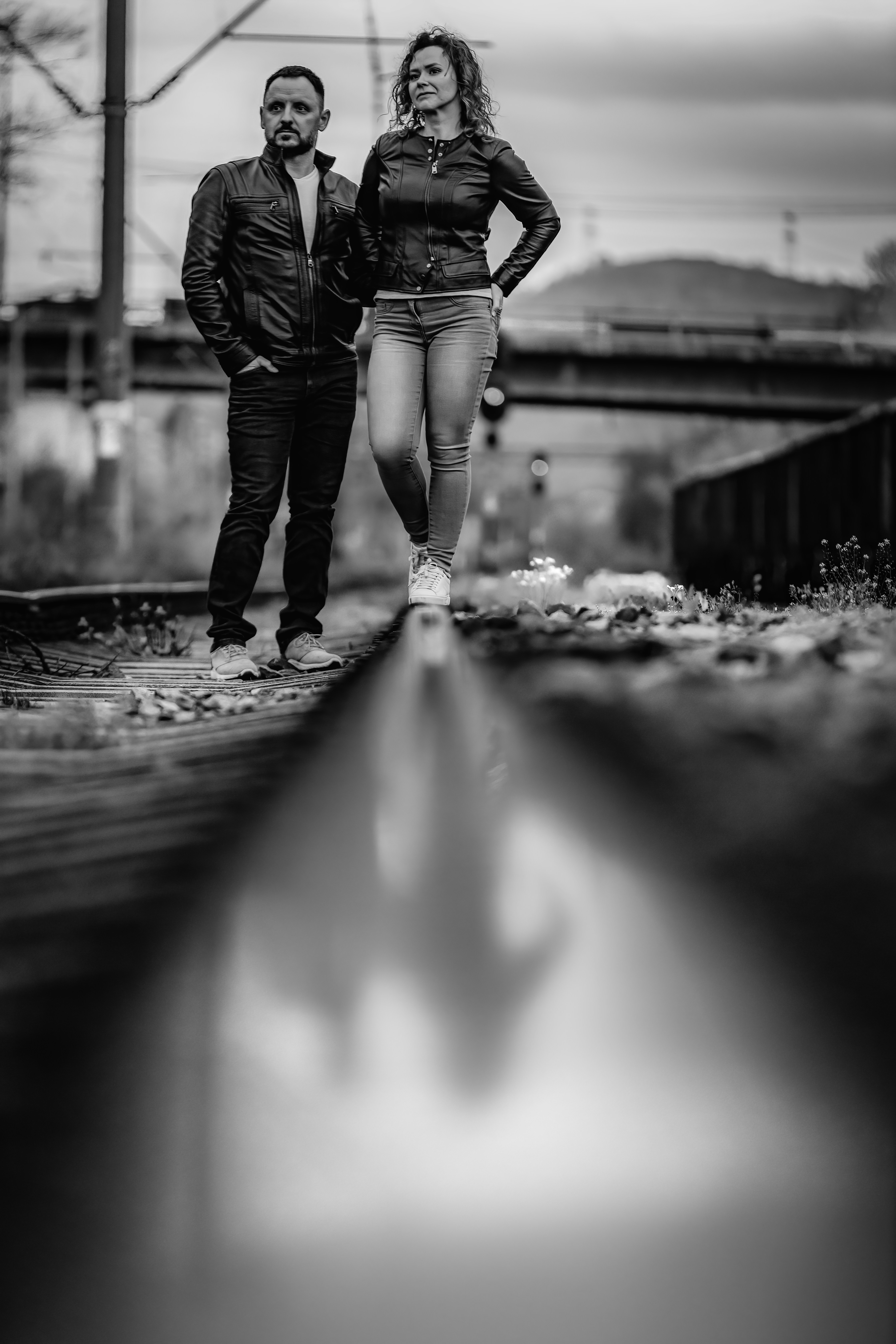 um homem e uma mulher em pé em um trilho de trem