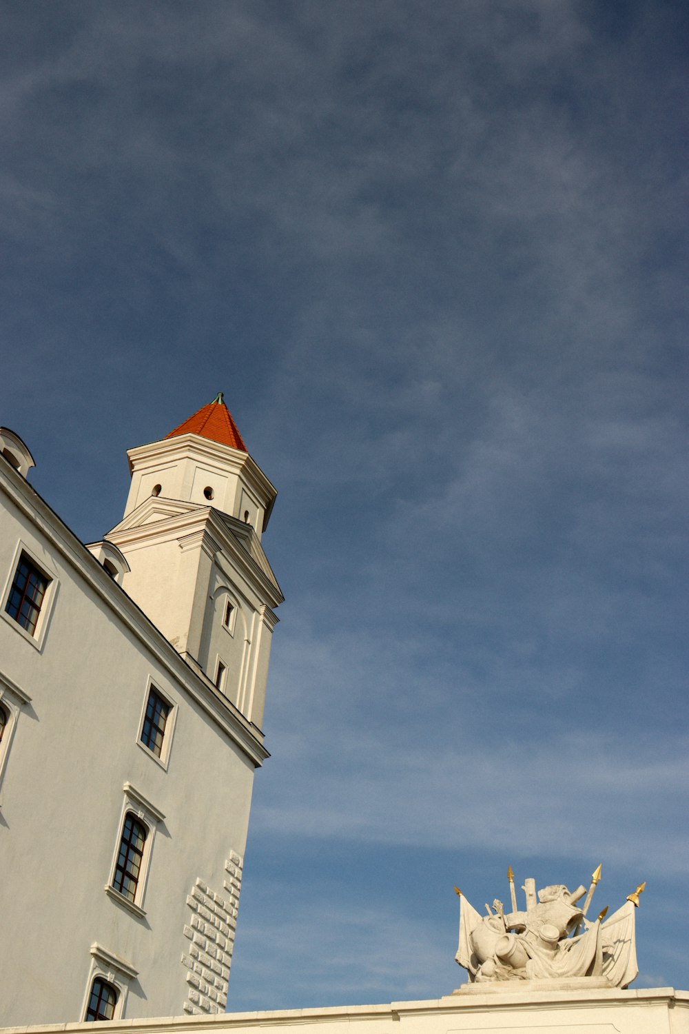 Ein hohes weißes Gebäude mit einer Uhr auf dem Zifferblatt