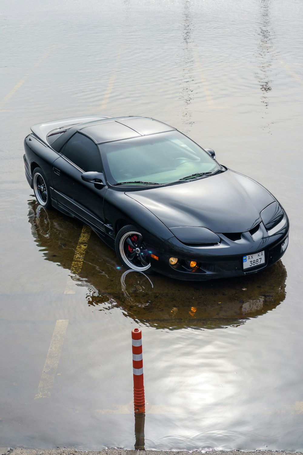 a black sports car in a flooded parking lot