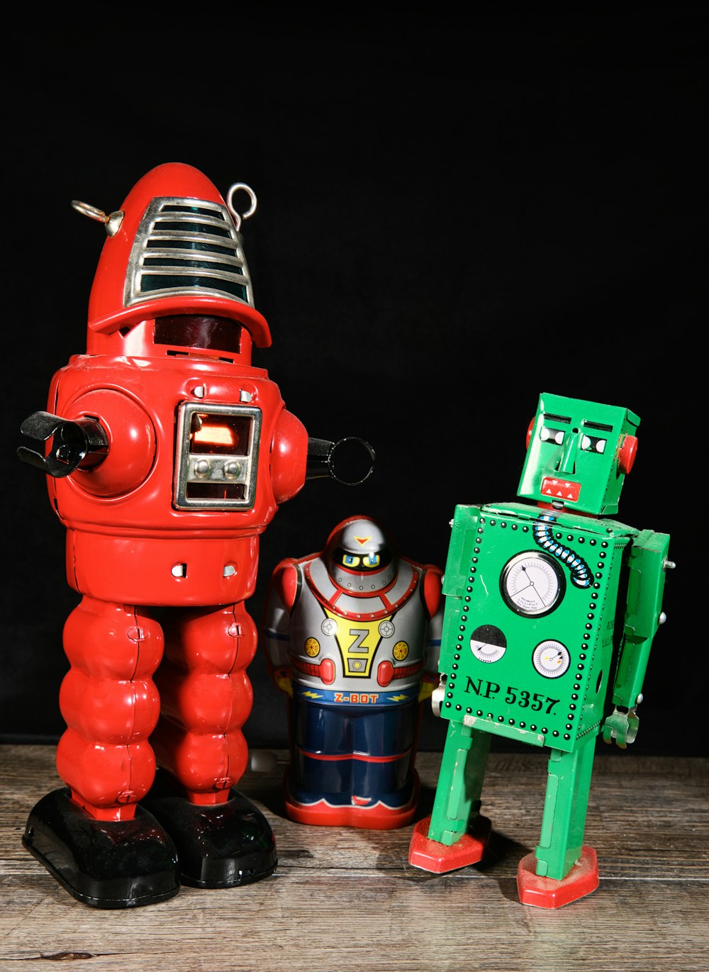 a red robot next to a green robot on a wooden table