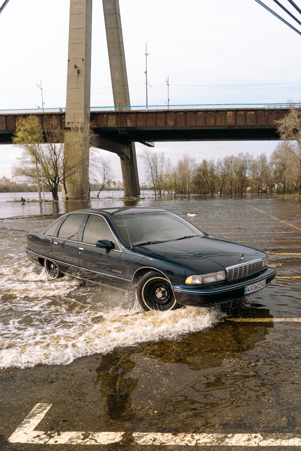 a car driving through a flooded parking lot