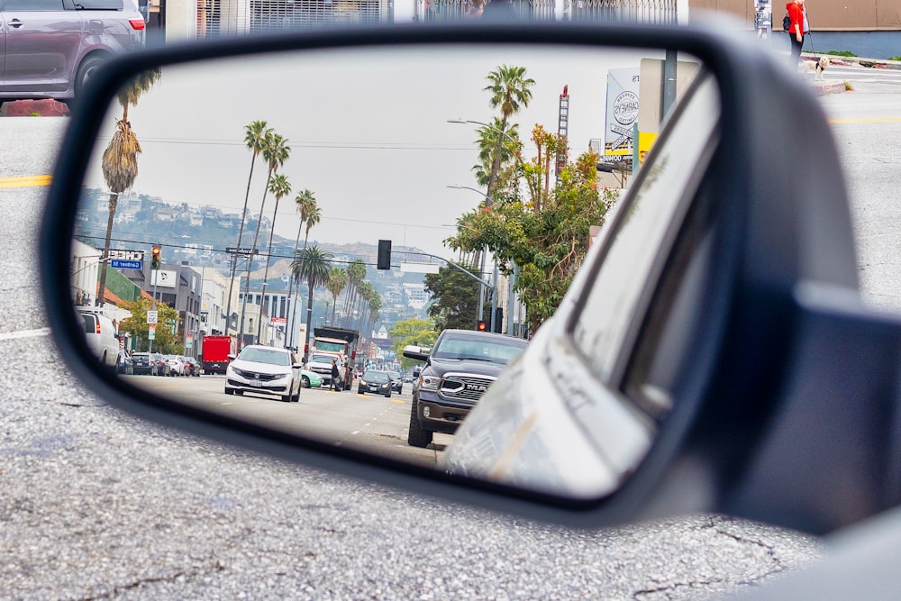 a car's side view mirror reflecting a city street