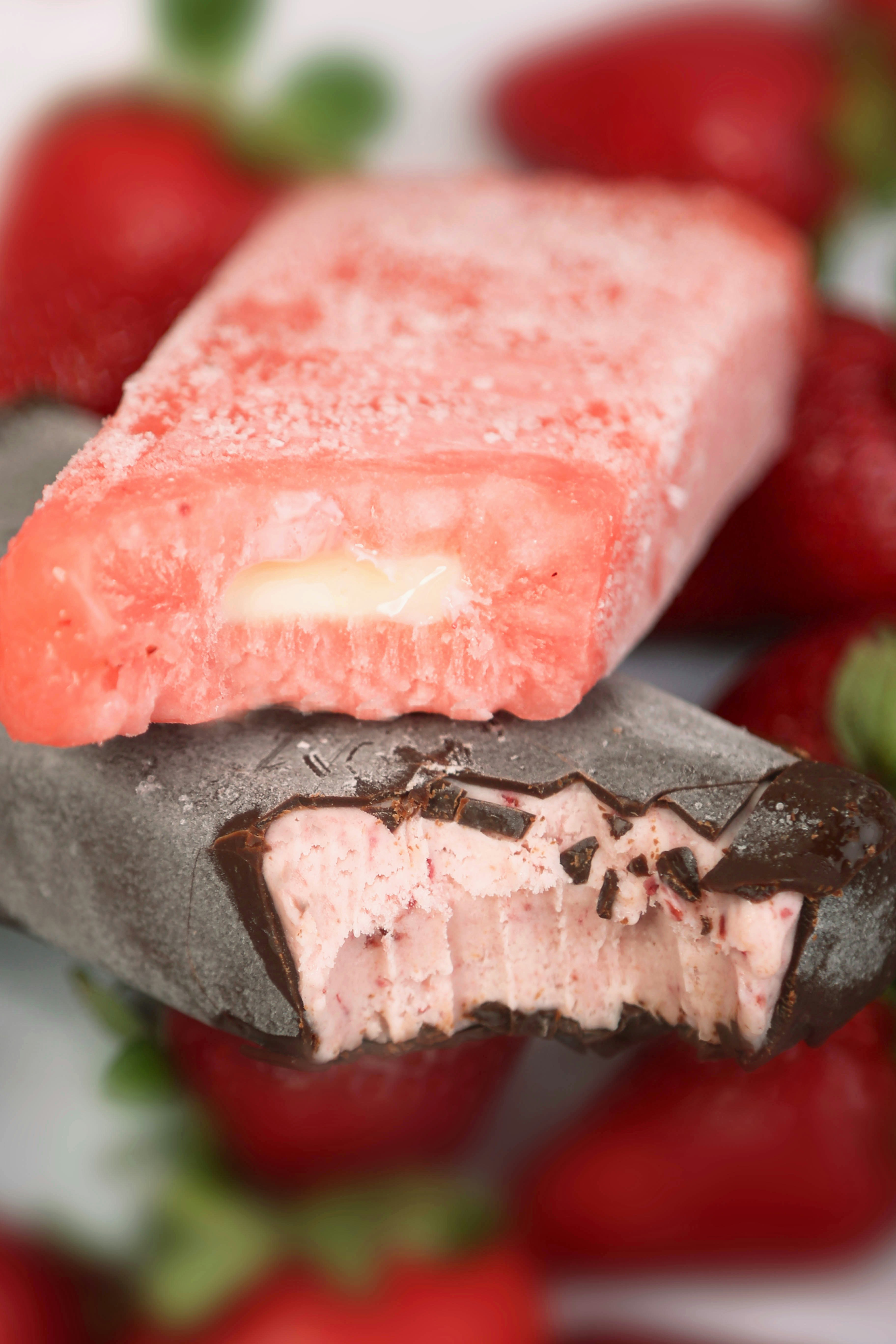 a close up of a piece of food with strawberries in the background