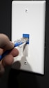 a person is holding a blue toothbrush in their hand