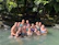 A group of women smiling together outdoors during a hiking trip in a lush green forest.