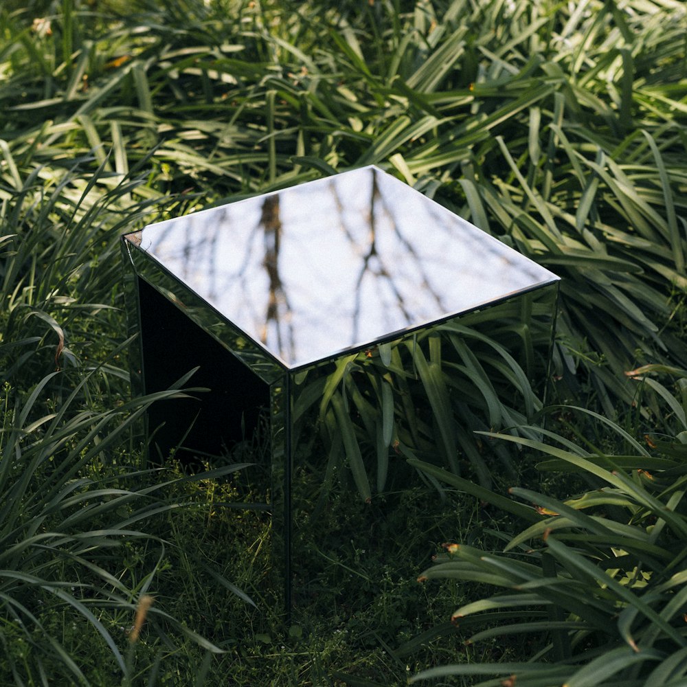 a mirrored table sitting in the middle of a field