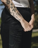 Close-up of a detailed black and grey tattoo sleeve on an arm.