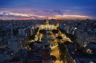 An aerial view of an iconic city skyline blending urban energy and timeless architecture at dusk.