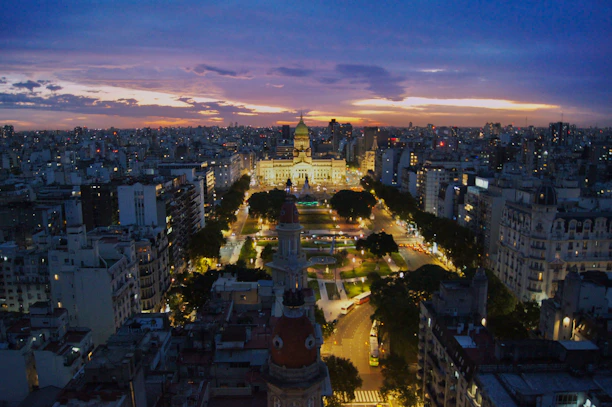 A dynamic aerial shot of New Delhi's skyline blending modern and traditional architecture at sunset.
