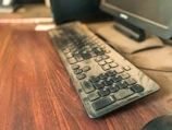 Close-up of a cleaner sanitizing a keyboard and mouse.