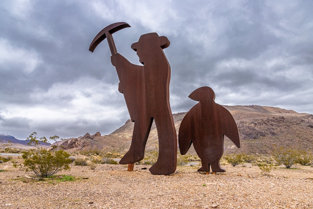 Una statua di un uomo che tiene un'ascia accanto a una statua di un pinguino