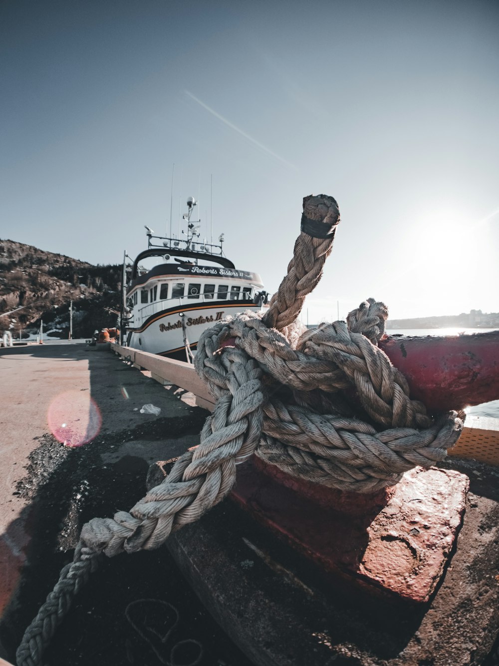 a boat docked at a dock with a rope