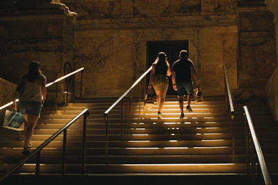 Guests walking through the grand staircase of the mansion during a guided tour, dressed in casual attire.
