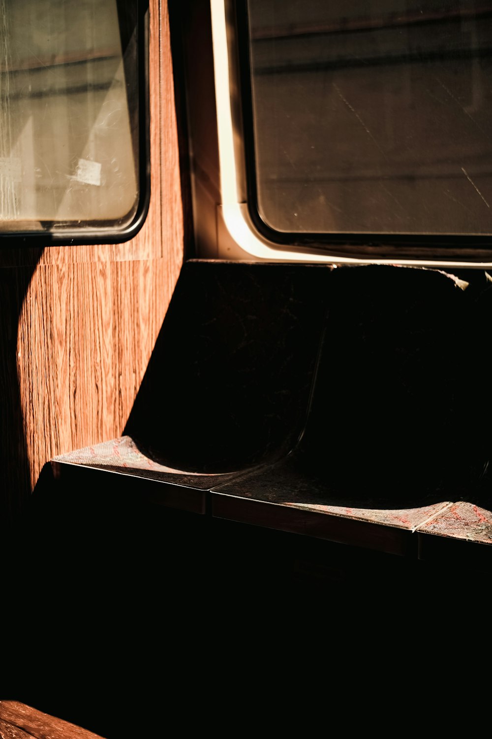 a wooden bench sitting in front of a window