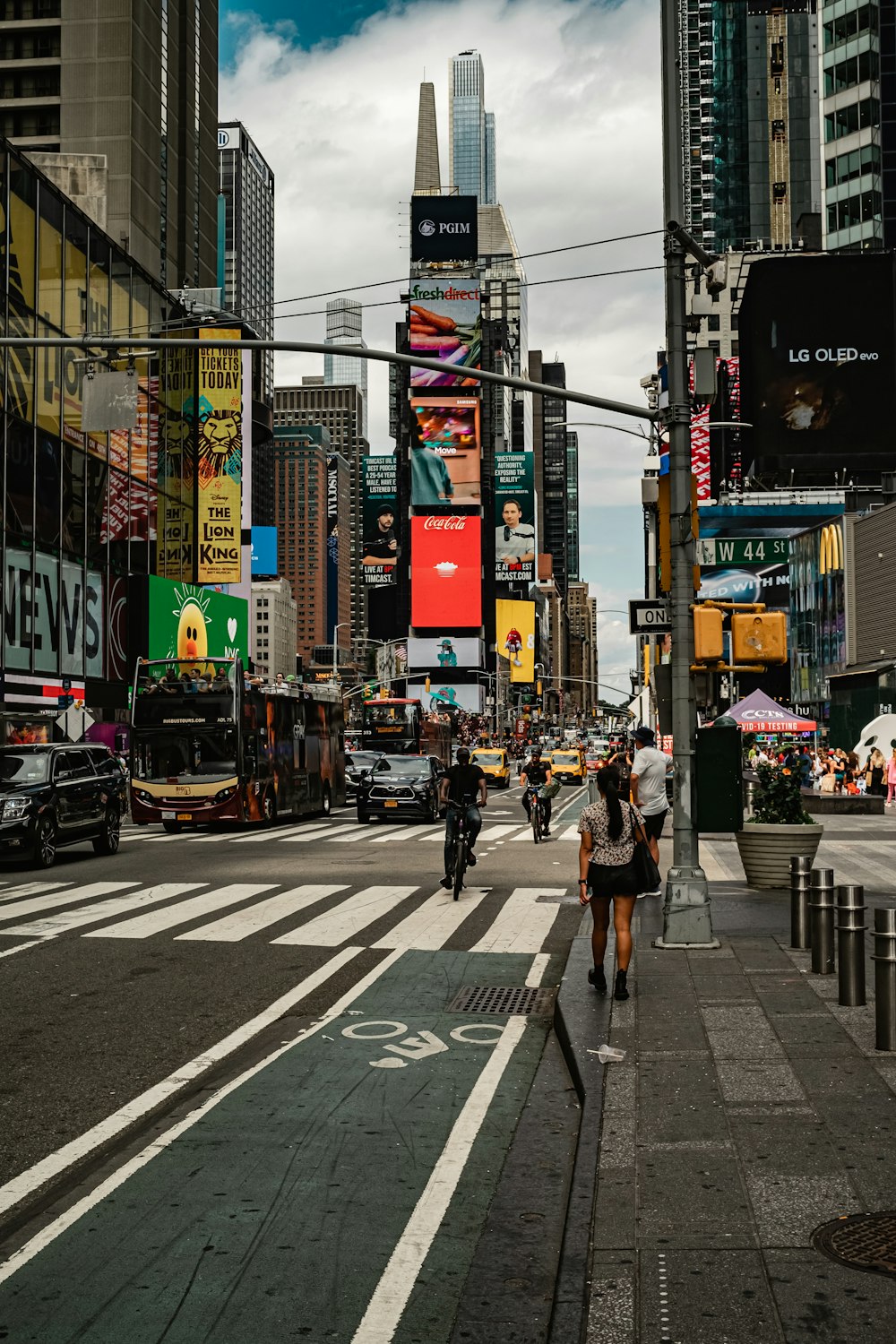 a group of people walking down a street next to tall buildings