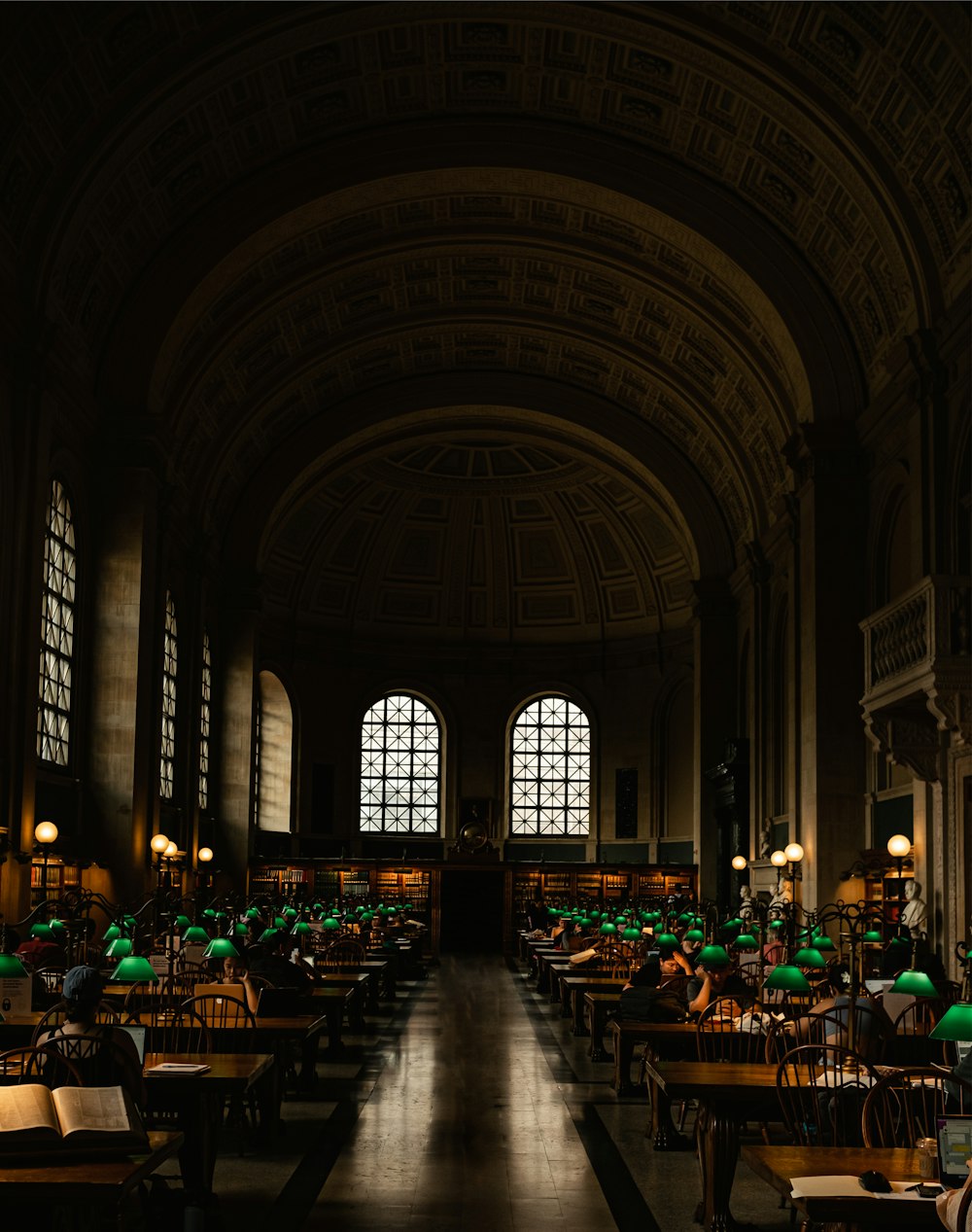 a dimly lit room with tables and green umbrellas