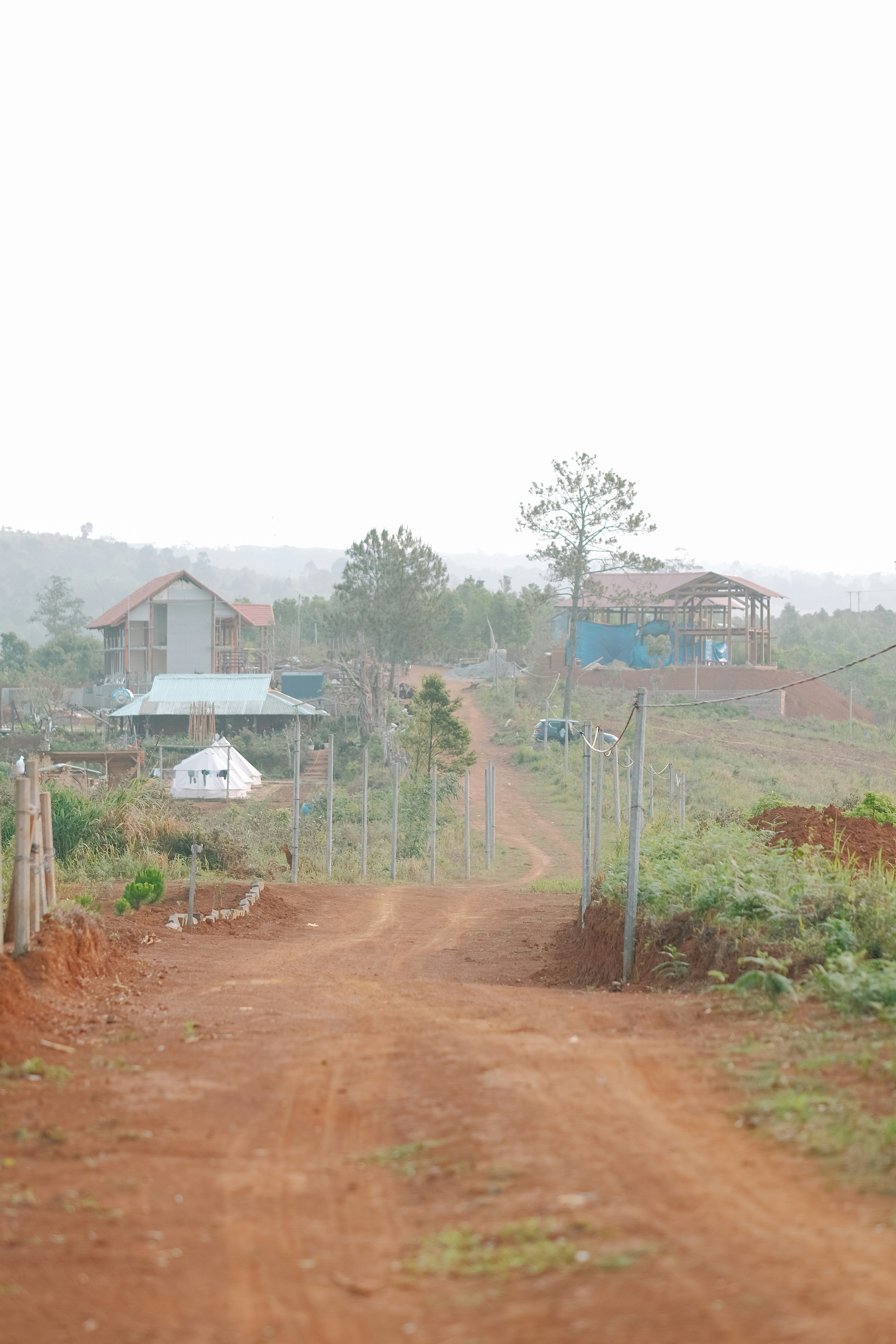 a dirt road with houses in the background
