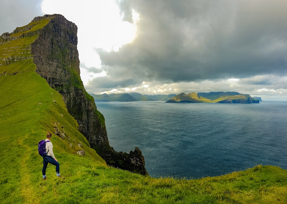 a man standing on top of a lush green hillside