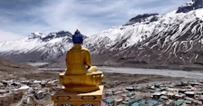 a golden buddha statue sitting on top of a mountain
