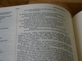 A close-up view of an open book displaying a page of text printed in two columns. The visible text includes chapters from the Old Testament, centered around a passage with the theme of divine judgment and comfort.