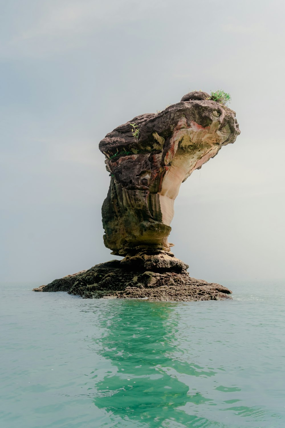 a large rock sticking out of the water