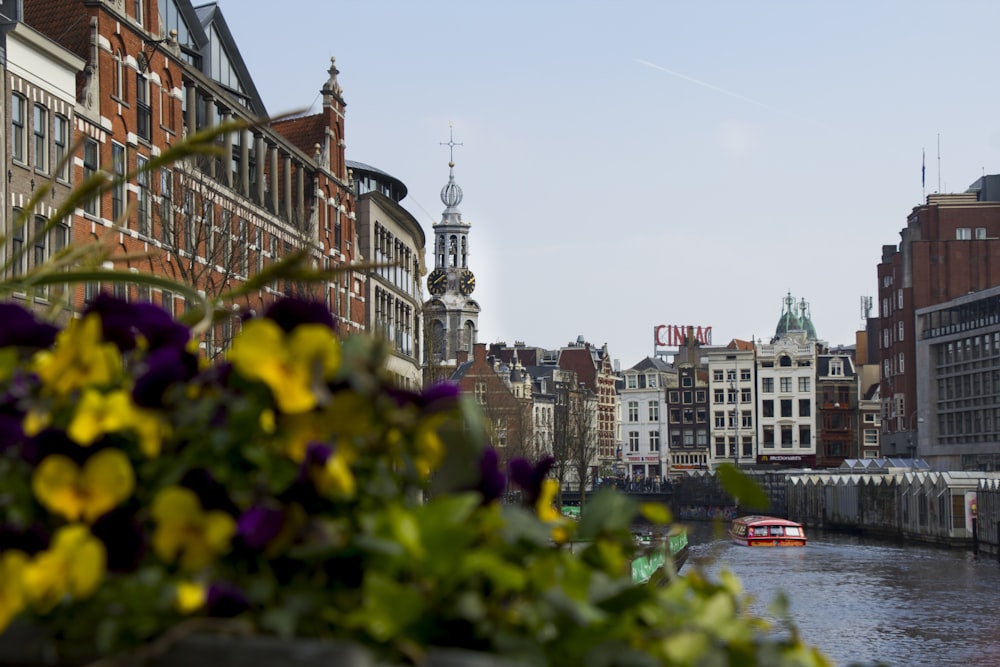 a boat traveling down a river next to tall buildings