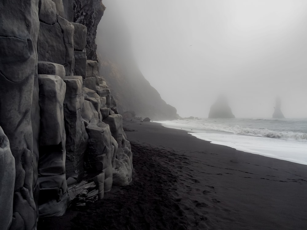 Una foto in bianco e nero di una spiaggia rocciosa