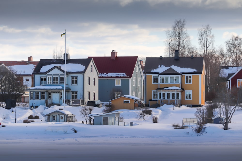 a row of houses covered in snow on a cloudy day