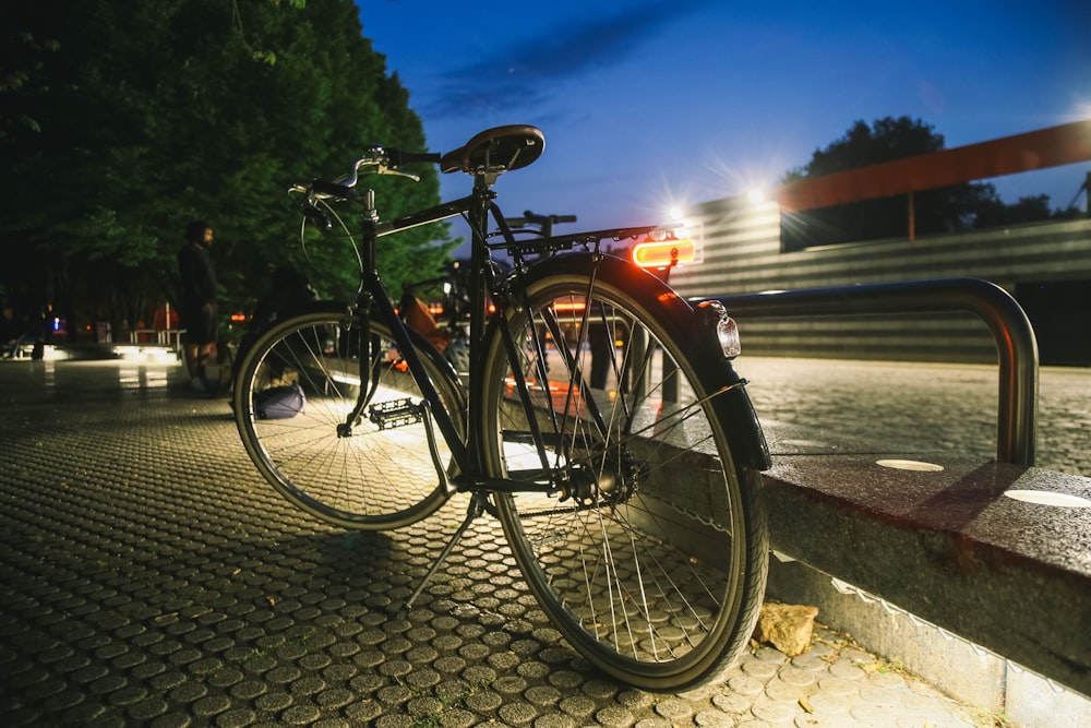 a bicycle parked on the side of a road at night