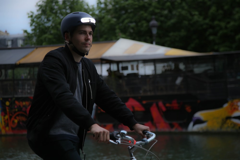 a man riding a bike next to a river