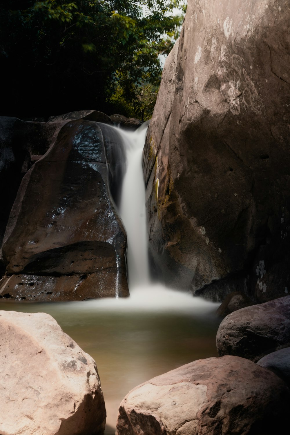 a small waterfall running between two large rocks