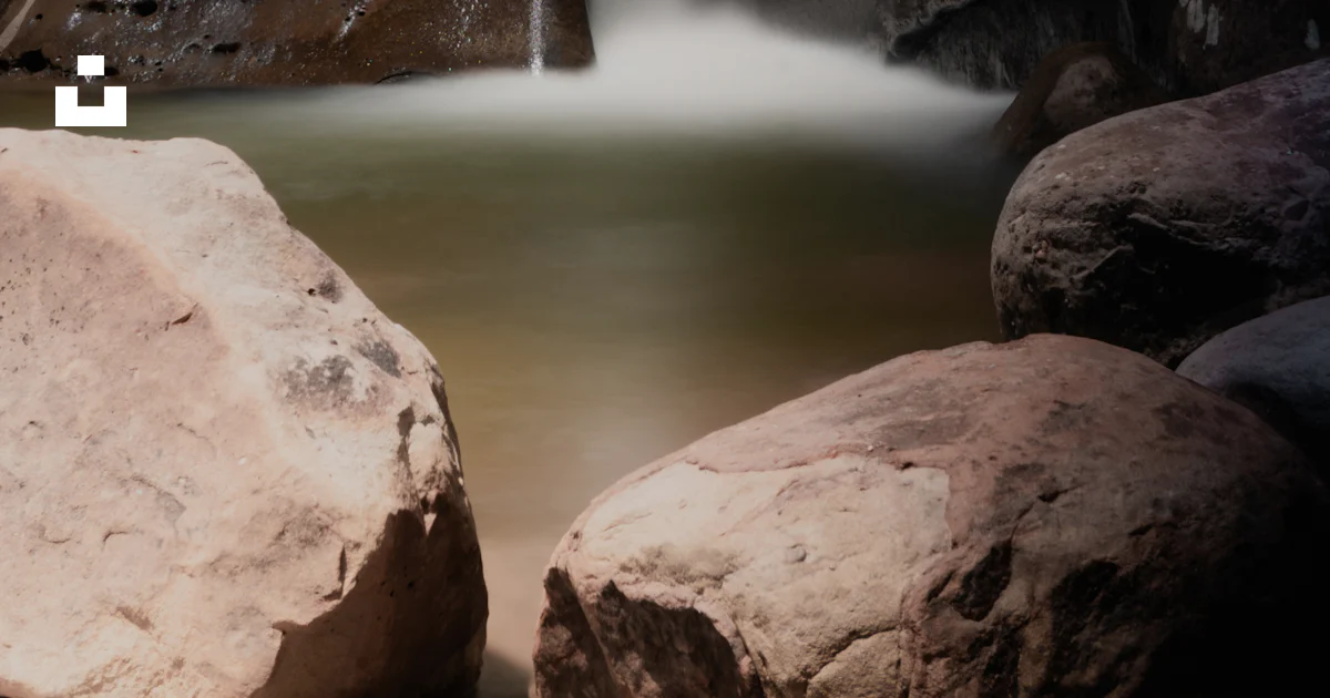 Small Waterfall Between Rocks A small waterfall running between two large rocks photo – Free Nature ...