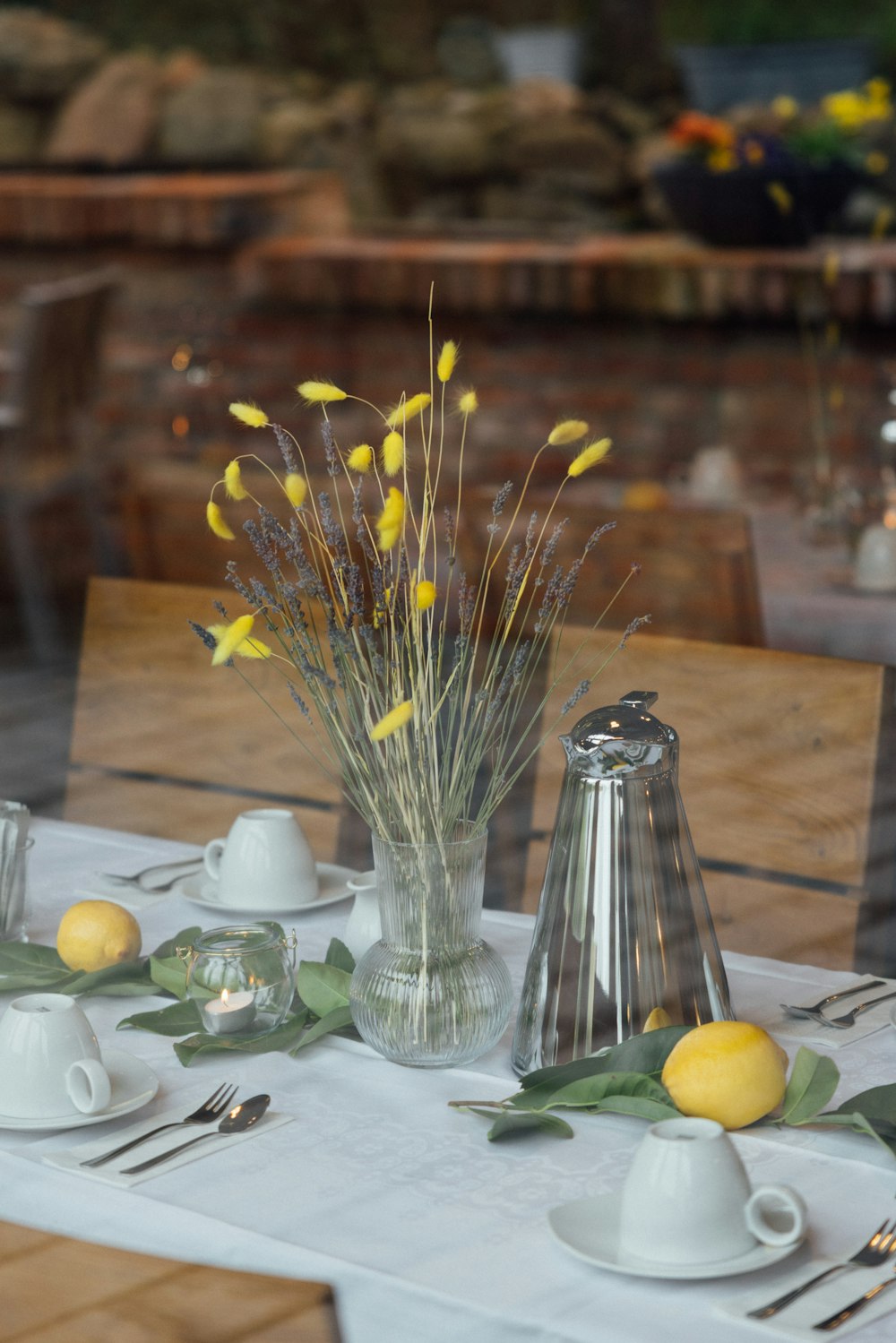 a table with a white table cloth and a vase with yellow flowers