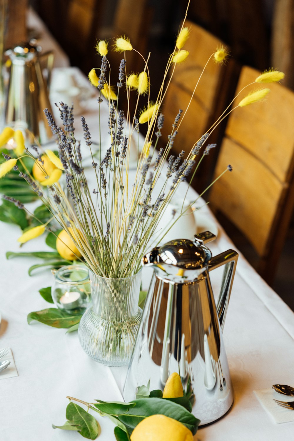 a long table with lemons and flowers on it