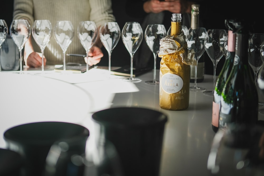 a table topped with lots of wine glasses and bottles