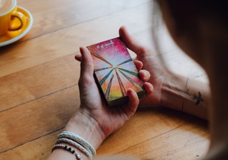 a woman sitting at a table holding a card