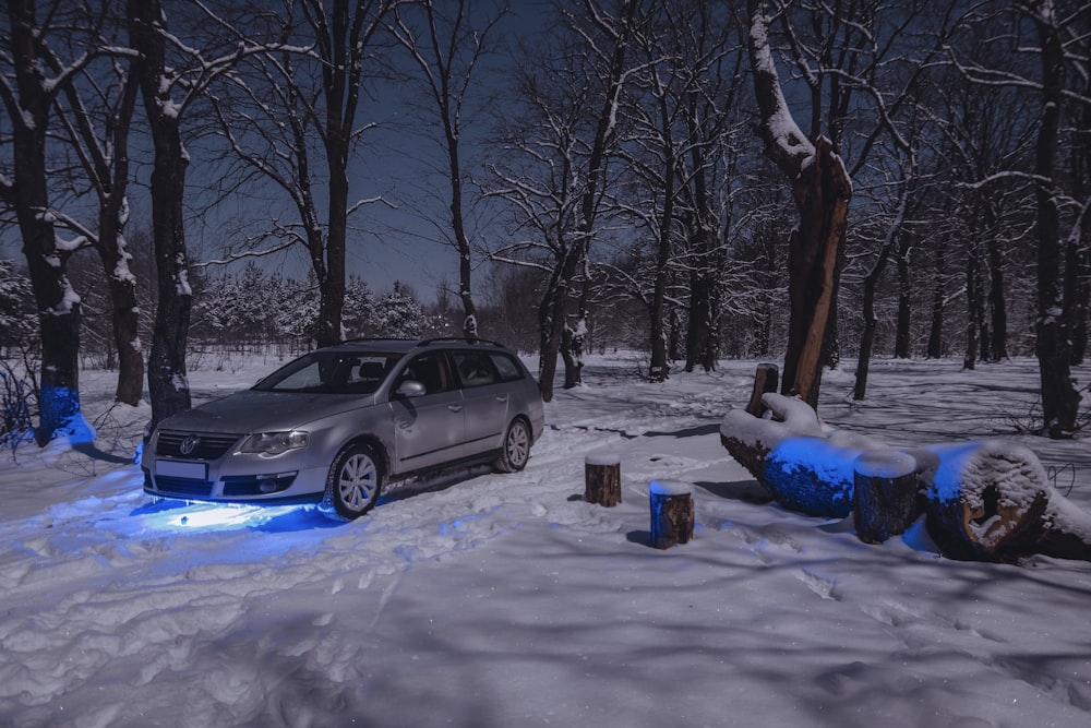 a car is parked in the snow near a fire hydrant