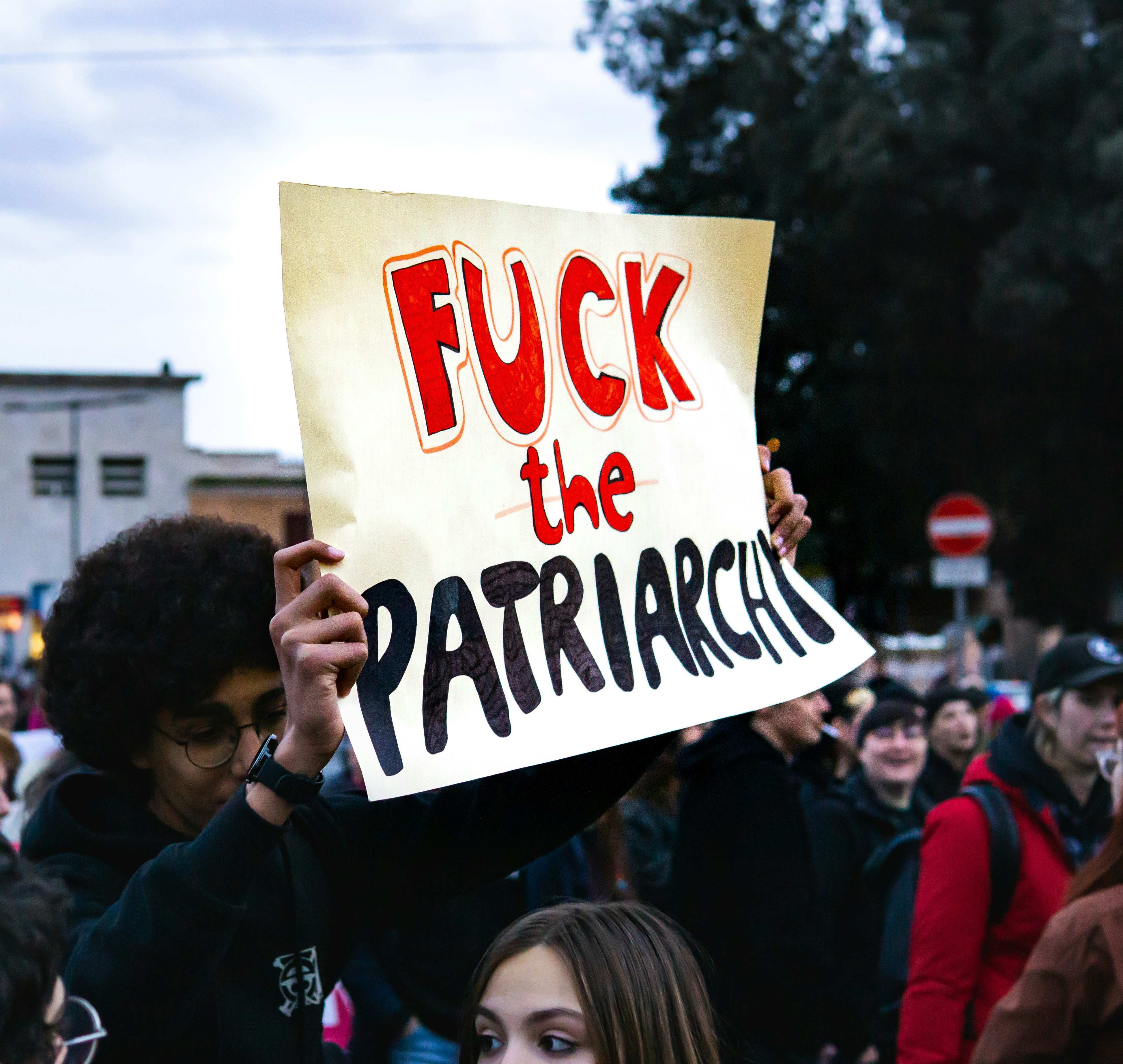 A rally with someone holding a sign that says, "Fuck the patriarchy."