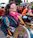 Portrait of a joyful woman playing djembe drum outdoors at sunset, surrounded by warm terracotta hues.