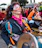 Portrait of a joyful woman playing djembe drum outdoors at sunset, surrounded by warm terracotta hues.