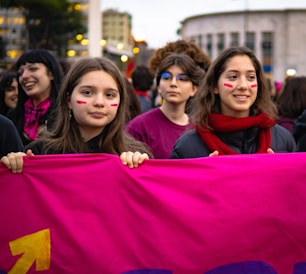 a group of women holding a large pink flag