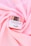 A jar of Supreme Facial Cream with a metallic lid is placed elegantly on soft, pink fabric. The cream is labeled as moisturizing, whitening, and revitalizing, with a confident tagline beneath the brand name.