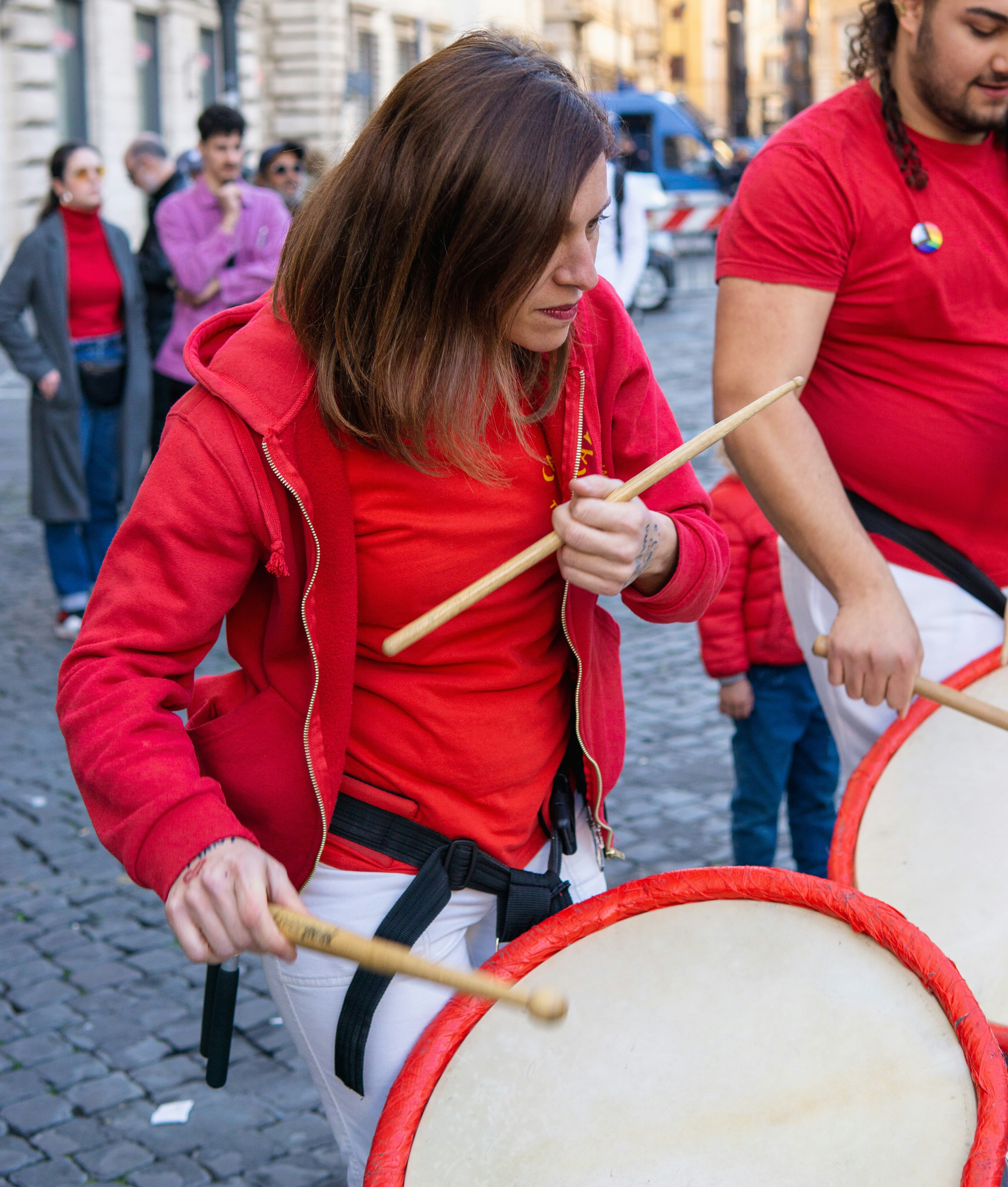 a man and a woman playing drums on the street