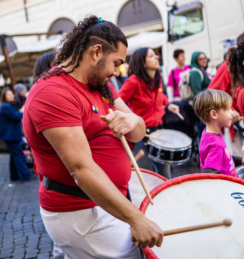 a man with dreadlocks is playing a drum