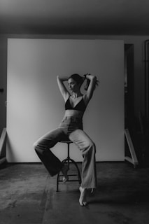 A confident woman posing in trendy casual wear against a minimalist background