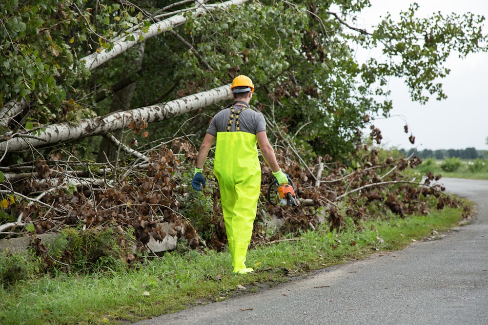 a man in yellow pants and a yellow hat walking down a road